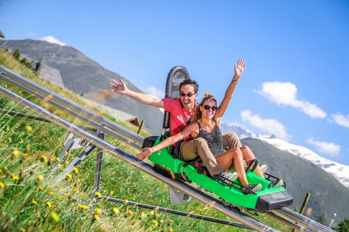 Un couple faisant de la luge l'été à l'Alpe d'Huez